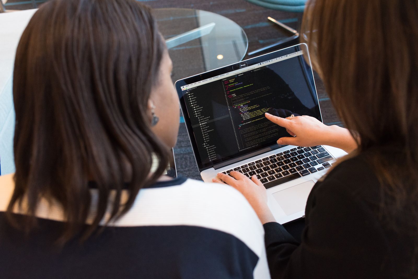 Two software developers reviewing code together at a laptop